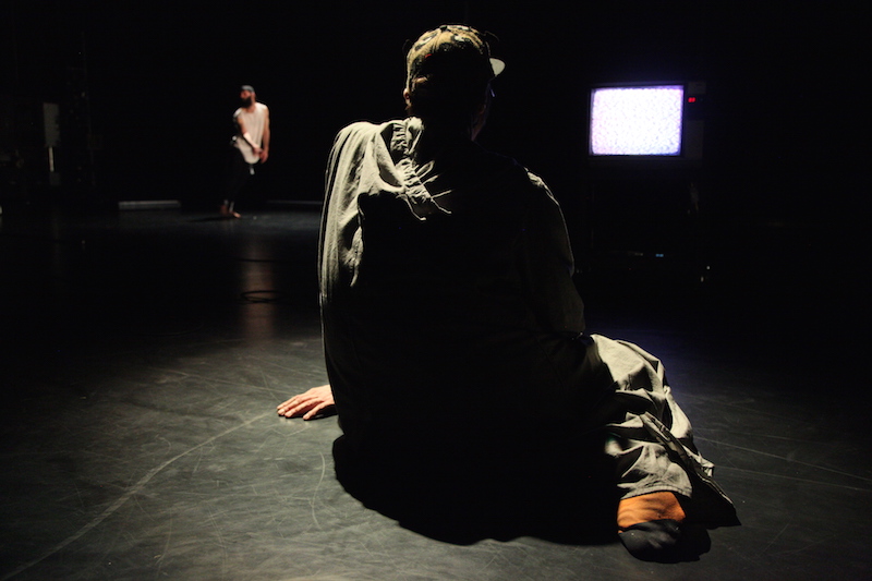 Chris Lancaster sits in front of a TV set, with his back towards the audience, before he launches into a tirade.